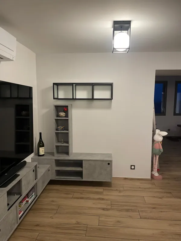 Meuble TV sur mesure : colonne de rangement et caissons suspendus effet béton, étagère en acier noir au mur